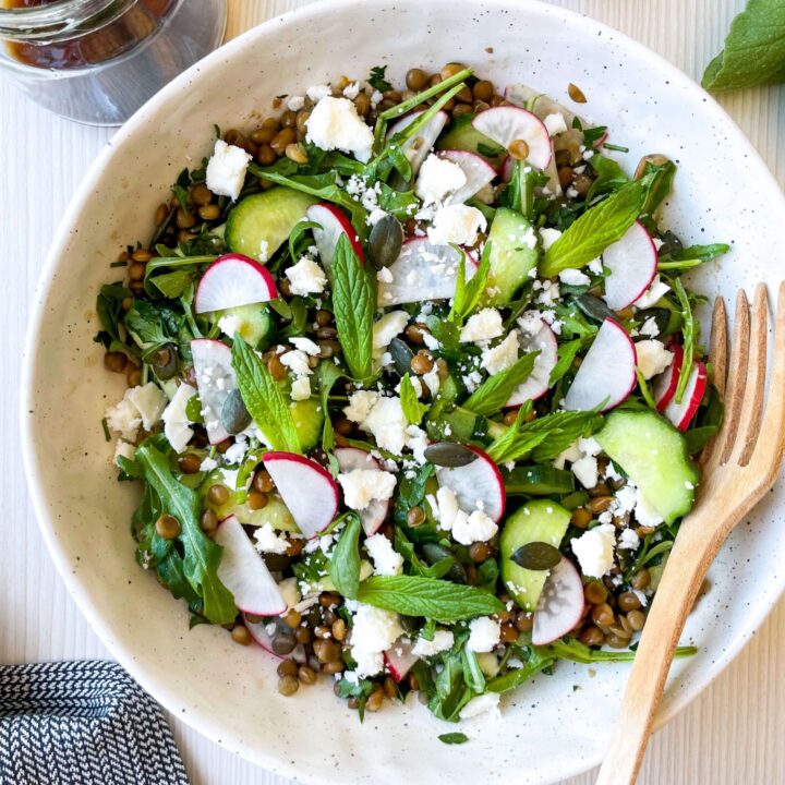 arugula cucumber salad in a white bowl